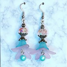 These pink and blue lucite and crystal bead earrings are so darling! Topped with a pink rondelle crystal bead, layered blue and pink acrylic flowers and finished off with a metallic blue Pearl dangle.  We can make these in different colors, just message us! Pink Flower Dangle Earrings With Beads, Pink Dangle Flower Earrings With Beads, Pink Dangling Beads Flower Drop Earrings, Pink Dangling Bead Flower Earrings, Blue Beaded Dangle Flower Earrings, Handmade Blue Dangle Flower Earrings, Whimsical Blue Dangle Flower Earrings, Whimsical Handmade Blue Flower Earrings, Blue Whimsical Dangle Flower Earrings