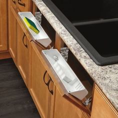 two white boxes sitting on the side of a counter next to a black dishwasher