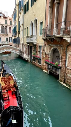 a boat is traveling down a canal in venice, italy with flowers on the railings