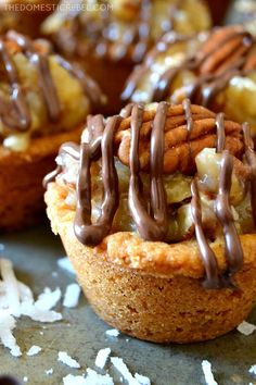 mini desserts with chocolate drizzled on top and nuts in the middle