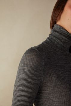 Long-sleeve high-neck tubular top made from a wool-silk blend. Stretch Merino Wool Turtleneck Top, Fine Knit High Neck Merino Wool Top, Fine Knit Merino Wool High Neck Top, High Neck Merino Wool Tops For Layering, High Neck Merino Wool Tops For Fall, Fine Knit Merino Wool Funnel Neck Top, Merino Wool Fine Knit Funnel Neck Top, Fall Merino Wool Tops With Seamless Collar, Fitted Merino Wool Tops For Layering