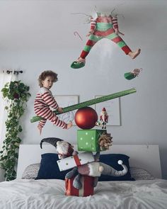 two children jumping on top of a bed in a room with white walls and decorations