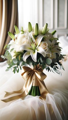 a bridal bouquet with white flowers and greenery on a bed in a hotel room