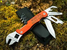 an orange and black swiss army knife with the words world's best dad written on it