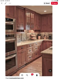 a large kitchen with wooden cabinets and stainless steel ovens, microwave, dishwasher and sink