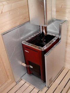 a small room with a stove inside of it and wood flooring on the walls