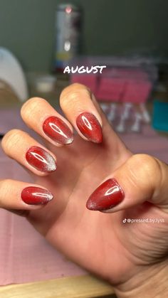 a woman's hand with red and white nail polishes on it, which reads august