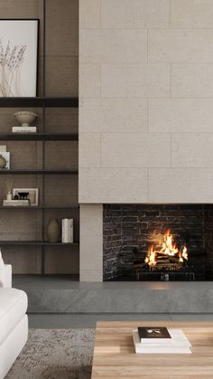 a living room with a fire place next to a white couch and bookcases