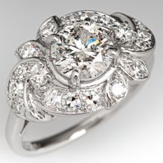 an antique style diamond engagement ring with three stone details on the shoulders and sides, set in white gold