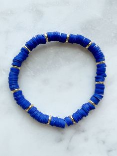 7’ bracelet. Royal blue clay and gold field beads. Cheap Blue Bracelets With Gold Beads, Cute Blue Bracelet Ideas, Blue Hand-strung Stretch Bracelet, Blue Bangle Jewelry With Large Beads, Everyday Blue Hand-strung Beaded Bracelets, Dark Blue Clay Bead Bracelet, Blue Spacer Beads Bangle Jewelry, Blue Stretch Bracelet With Gold Round Beads, Blue Stretch Bracelet With Gold Beads