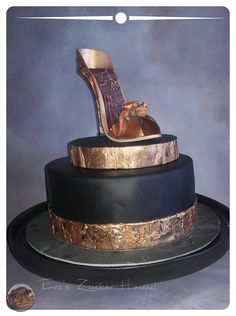 there is a cake with high heel shoes on the top and gold trimmings