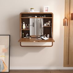 an open medicine cabinet in the corner of a room next to a painting and framed photograph