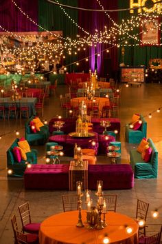 a room filled with lots of tables covered in purple and orange chairs next to each other