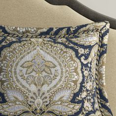 a blue and gold pillow sitting on top of a bed