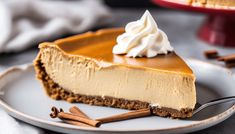 a slice of cheesecake on a plate with whipped cream and cinnamon sticks around it