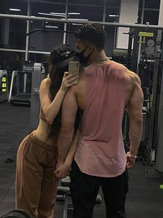 a man and woman standing next to each other in a gym