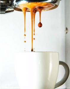 coffee being poured into a white cup