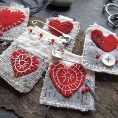 some red and white hearts are on small pieces of fabric with buttons attached to them