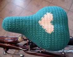 a close up of a bike with a knitted seat cover