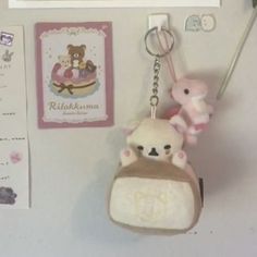 a keychain with a stuffed animal hanging from it's side on a wall