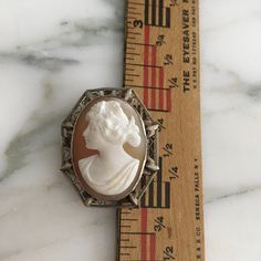 "14K white gold Small cameo. Very ornate, filigree setting holds a wonderful carved cameo of a beautiful Victorian women from the Edwardian era. This cameo can be both a brooch or a pendant. Brooch was made in the early 1900's and measures over 1 3/16\" in length X approximately 1\" in width. What makes this cameo so special is the fine detailed carving and wonderful delicate intricate frame, a tiny treasure. Shipping includes insurance. As always, local pickup is available. Aphrodite's Antique White Oval Brooch For Formal Occasions, Victorian White Cabochon Brooches, White Victorian Cabochon Brooches, White Cameo Brooch For Wedding, White Cameo Brooch For Formal Occasions, Antique White Brooch For Formal Occasions, White Cameo Brooches For Formal Occasion, White Cameo Brooches For Wedding, White Oval Cameo Brooches