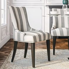 a pair of striped chairs sitting on top of a rug