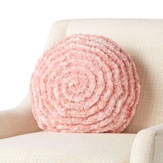 a pink pillow sitting on top of a white chair