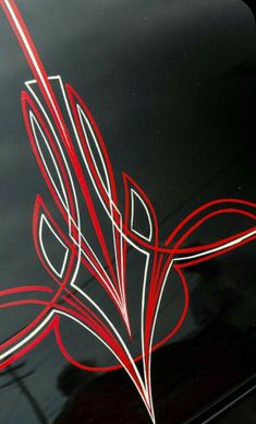 a close up view of the emblem on a black car with red and white lines