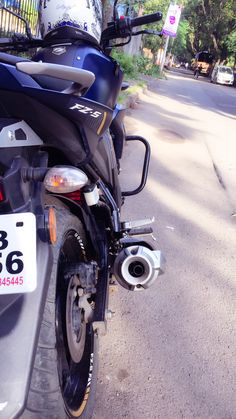 the motorcycle is parked on the side of the road with its license plate attached to it