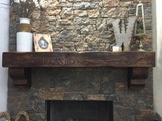 a stone fireplace with wooden mantels and other items on the mantle in front of it