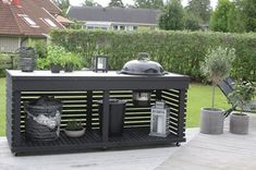 an outdoor bbq with grill and potted plants