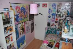 a room with many pictures on the wall and a pink lamp hanging from the ceiling