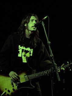 a man with long hair playing a guitar