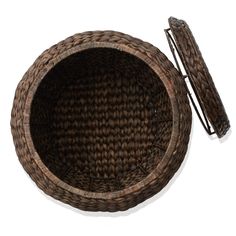 a woven basket with two handles and an empty lid next to it on a white surface