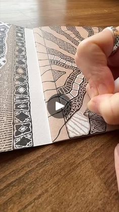 someone is cutting out an intricate design on a piece of paper that they are holding