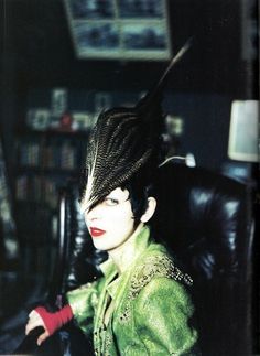 a woman with black hair sitting in a chair