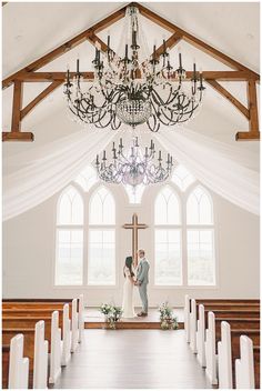 a bride and groom standing in front of the alter at their wedding ceremony with chandelier