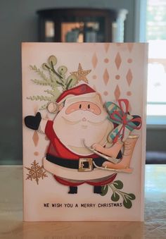 a christmas card with a santa clause holding a gift bag and writing on it,