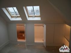 an empty room with two skylights above it