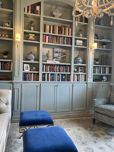 a living room filled with lots of bookshelves next to a couch and chair