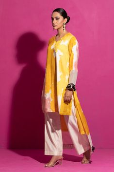 Embrace the allure of this yellow abstract print kurta set, meticulously handcrafted in cotton satin. The a-line asymmetrical kurta with full sleeves features hand-painted motifs on a cotton satin base, paired harmoniously with ivory palazzo pants in chanderi. The ensemble is highlighted with delicate hand embroidery, presenting a two-piece masterpiece of contemporary elegance. Yellow Silk Sets With Printed Motifs, Yellow Silk Long Sleeve Kurta, Summer Silk Kurta With Digital Print, Yellow Printed Cotton Silk Sets, Yellow Cotton Silk Sets With Printed Motifs, Unstitched Yellow Silk Kurta, Silk Kurta With Digital Print And Long Sleeves, Silk Straight Kurta With Digital Print, Eid Tunic Kurta With Digital Print