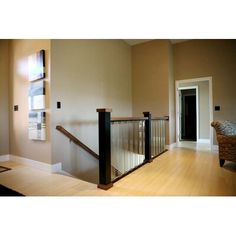 an empty living room with wooden floors and stairs