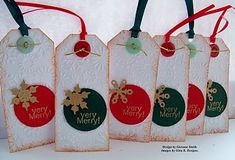 four tags with christmas ornaments hanging from them