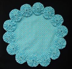 a blue and white doily with polka dots on the edges is shown in front of a black background