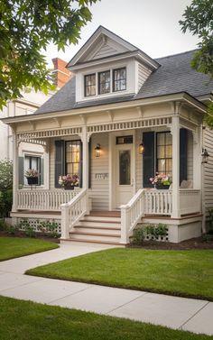 a white house with black shutters on the front porch and steps leading up to it