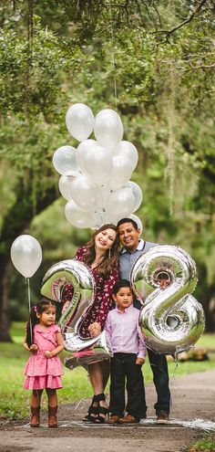 a family poses for a photo with balloons and the number twenty two in front of them