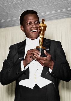 a man in a tuxedo is holding an award for best performance by an actor