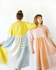 two women standing next to each other wearing dresses with different colors and patterns on them