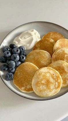 pancakes with blueberries and whipped cream on a plate