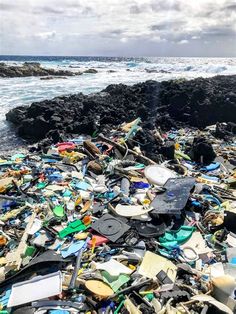 a pile of trash sitting on top of a beach next to the ocean